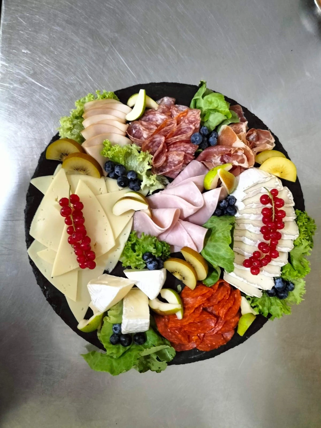 Deutsches Haus - Restaurant - eine Wurstplatte, die aus einer Auswahl an Wurstwaren besteht, die mit verschiedenen Beilagen serviert werden.